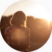 Photo contre-jour d'une femme regardant le coucher de soleil.