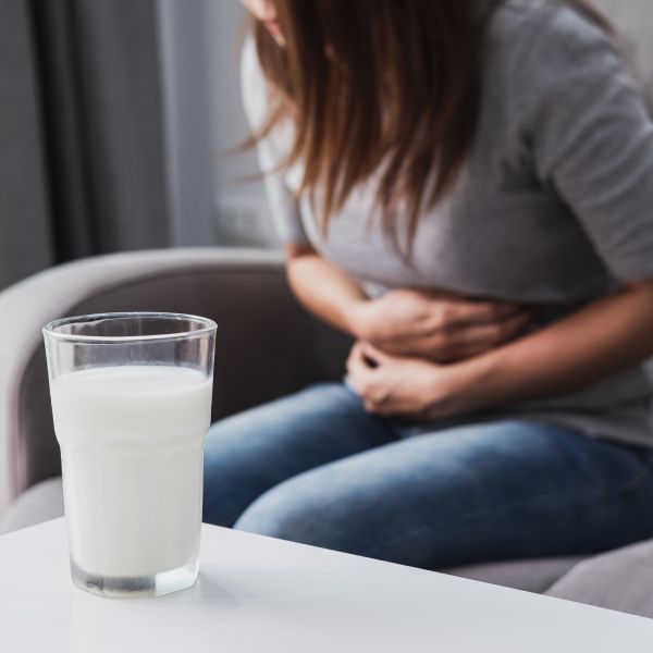 Une femme se tient l'abdomen sous la douleur.