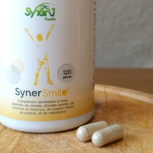 Un flacon de SynerSMILE avec deux gélules.