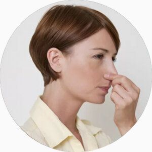Une femme se pince le nez pour pratiquer le test BOLT.