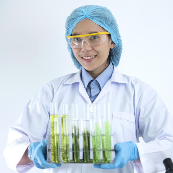Une scientifique avec des tubes de micro algues.