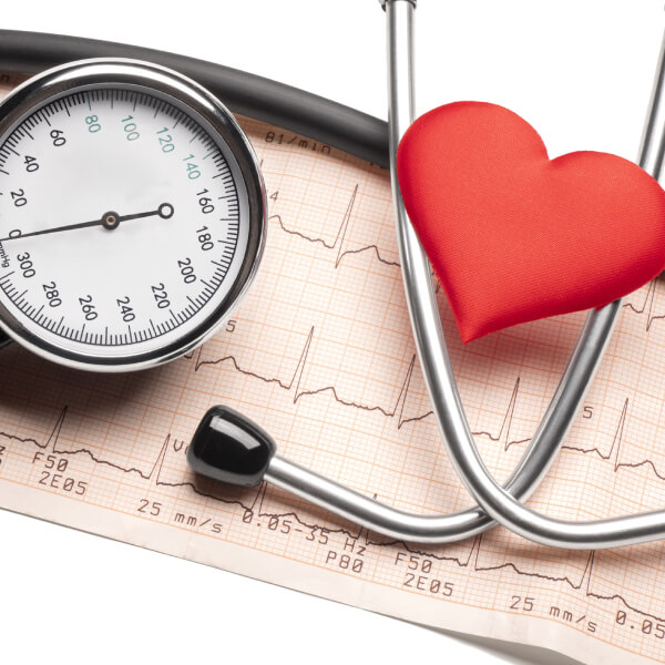Un sphygmomanomètre à coté d'un stéthoscope et d'un coeur rouge.