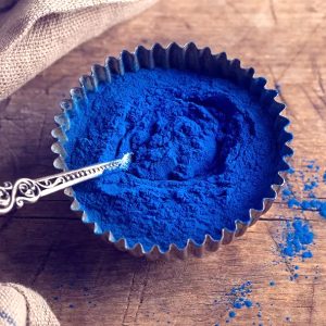 Un bol rempli de phycocyanine bleue avec une cuillère.