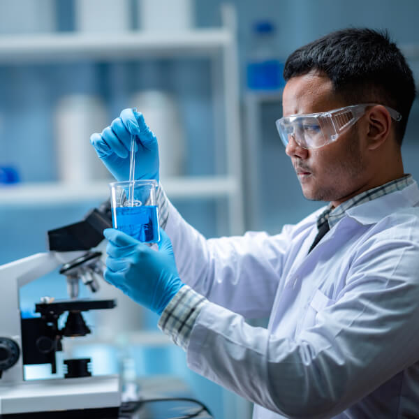 Un scientifique en laboratoire observe une éprouvette pour détemriner un lien entre klamath et cellule souche.