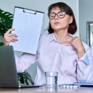 Une dame en ménopause subit des bouffées de chaleur au bureau.