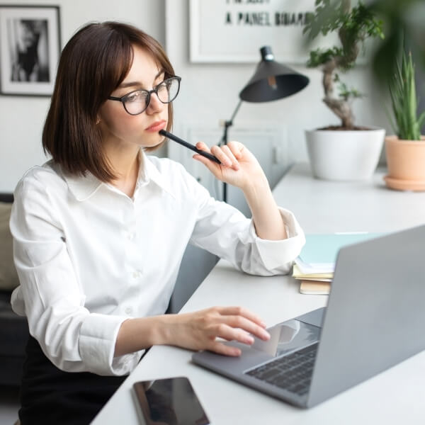 Une femme pensive devant son ordinateur se demande comment bien choisir son algue de Klamath AFA.
