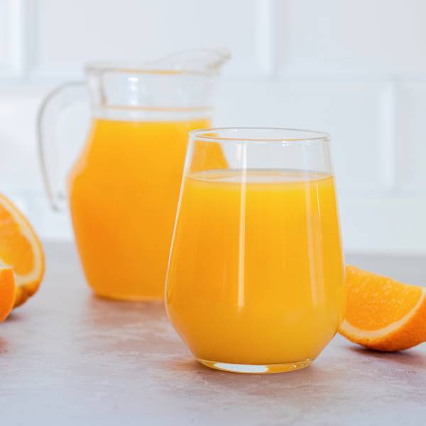 Du jus d'orange en carafe et dans un verre.