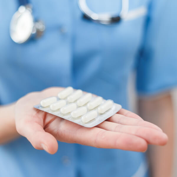 Un docteur en blouse présente des antibiotiques.