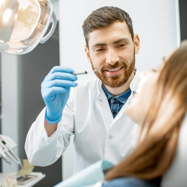 Un dentiste examine une patiente.
