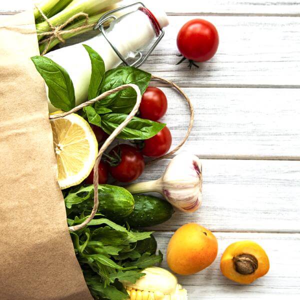 Un sac de courses remplis de légumes.