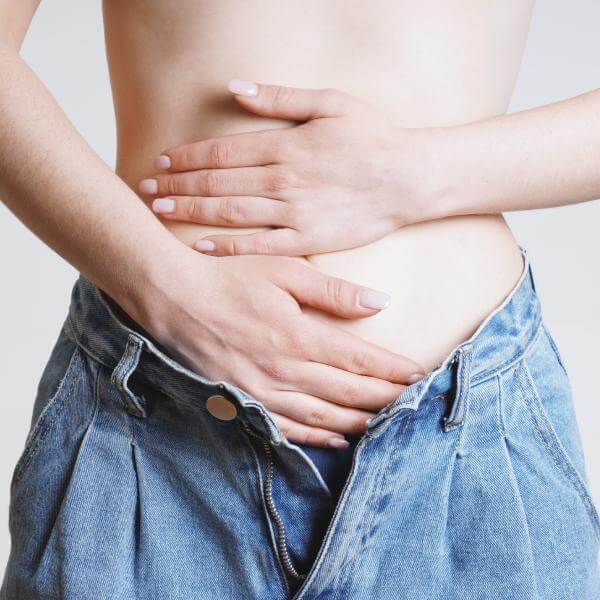 Deux mains sur un abdomen.