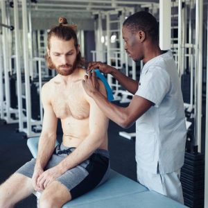 Un docteur traite un sportif pour accélérer et optimiser sa récupération musculaire.