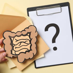 Un intestin en papier sur un document de test de perméabilité intestinale avec un point d'interrogation.