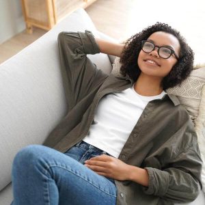 Une jeune femme allongée sur un canapé mets son intestin au repos.