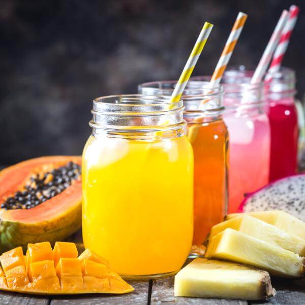 Des verres de jus de fruits avec des fruits en tranches.