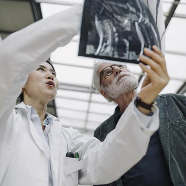 Un docteur et son patient examine une radiographie d'un estomac malade.