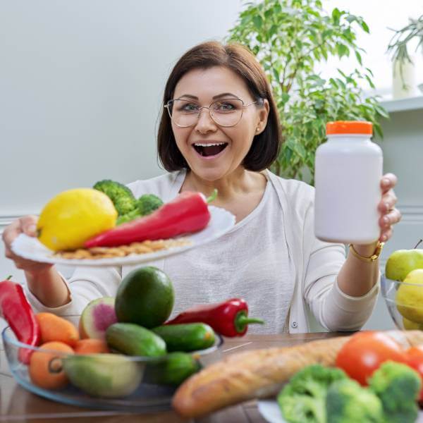 Une femme enthousiaste présente des aliments sains pour le pancréas.