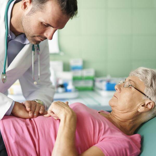 Un médecin examine l'abdomen d'une patiente.