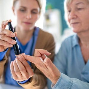 Un docteur mesure la glycémie sanguine d'une patiente atteinte de diabète.