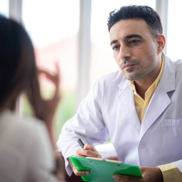 Un docteur spécialiste en intoxication aux métaux lourds écoute sa patiente attentivement.