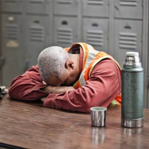 Un travailleur fait la siestes, épuisé par les symptômes d'une intoxication aux métaux lourds