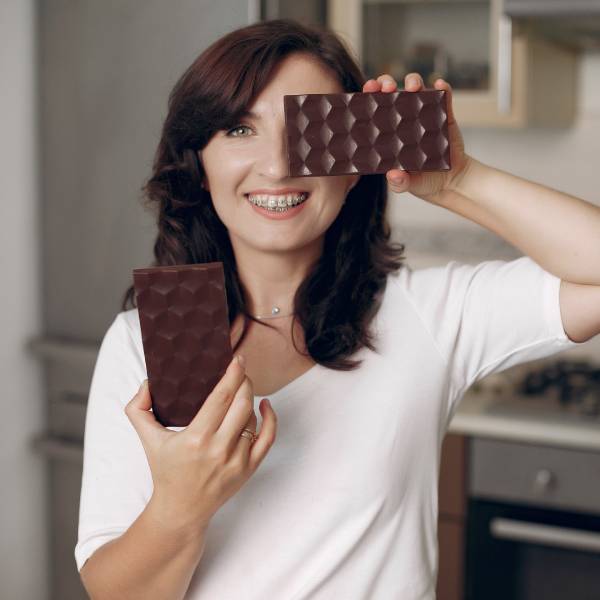 Une femme avec deux barres de chocolat noir.