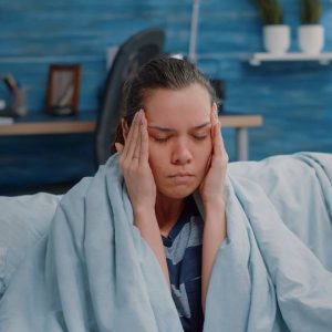 Une jeune femme subi un mal de tête, un effet secondaire d'une détox aux métaux lourds.