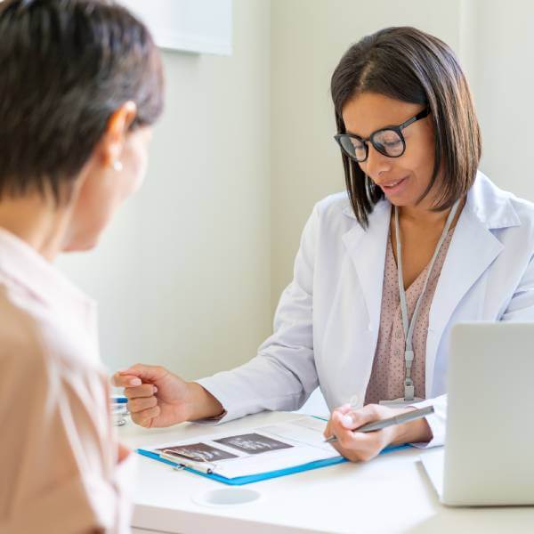 Une médecin et son patient discutent d'un bilan sanguin sur les taux de métaux lourds.