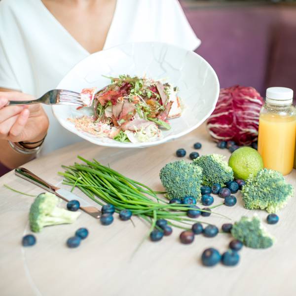 Une assiette pleine de légumes sur une table riche en aliments sains pour nettoyer le foie naturellement.