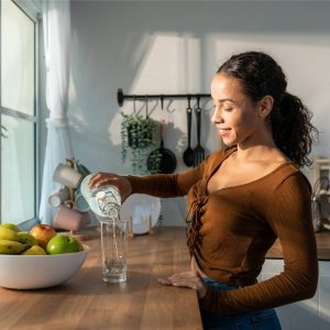 Une jeune femme se prépare une tisane pour nettoyer son foie naturellement et rapidement.