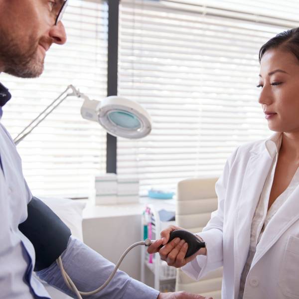 Une jeune médecin vérifie la pression artérielle d'un patient.