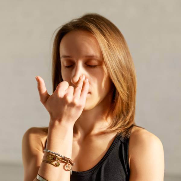 Une jeune femme pratique un exercice de respiration profonde pour améliorer le taux d'oxygène dans le sang.