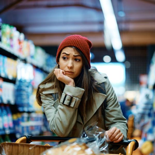 Une jeune femme attristée dans un supermarché.