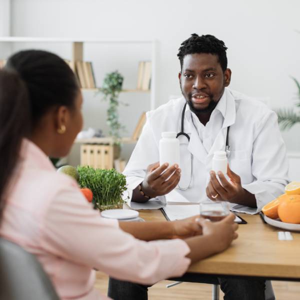 Un médecin explique à sa patiente quels aliments éviter et favoriser en phases d'accalmie et de poussée de maladie de Crohn.