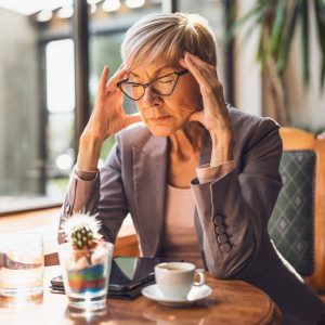 Une dame dans un café expérimente un coup de stress et d'anxiété.