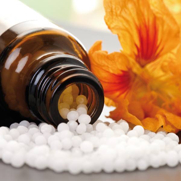 Gros plan sur un flacon de granulés homéopathiques.