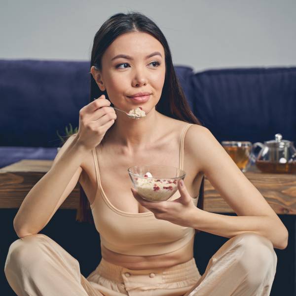 Une jeune femme asiatique mange un probiotique pour maigrir.